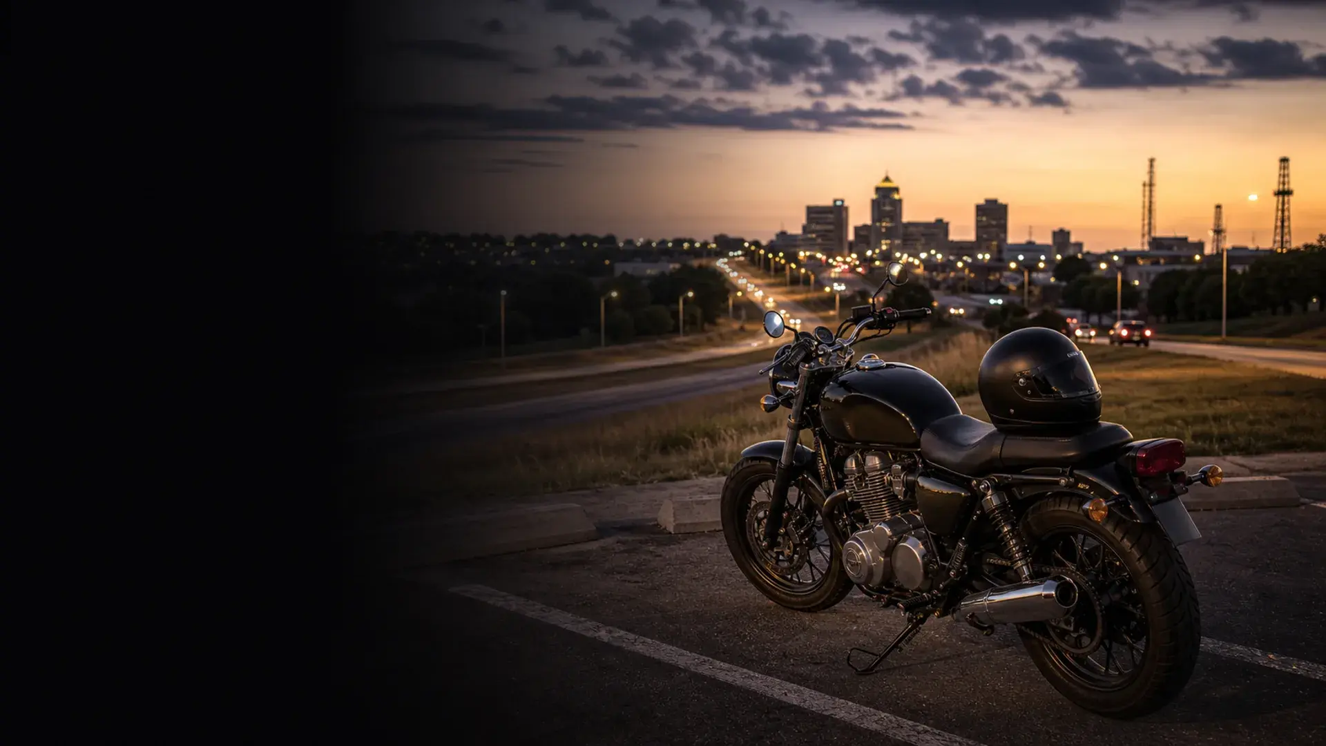 Motorcycle parked safely near a Bartlesville commuter corridor with downtown lights at dusk