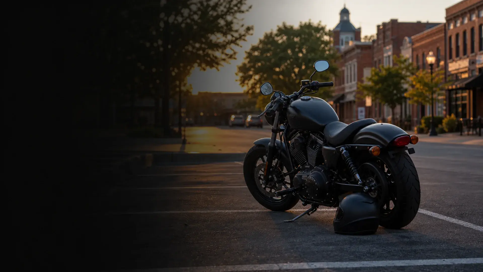 Motorcycle parked safely near a Stillwater college-town street and brick downtown corridor at golden hour