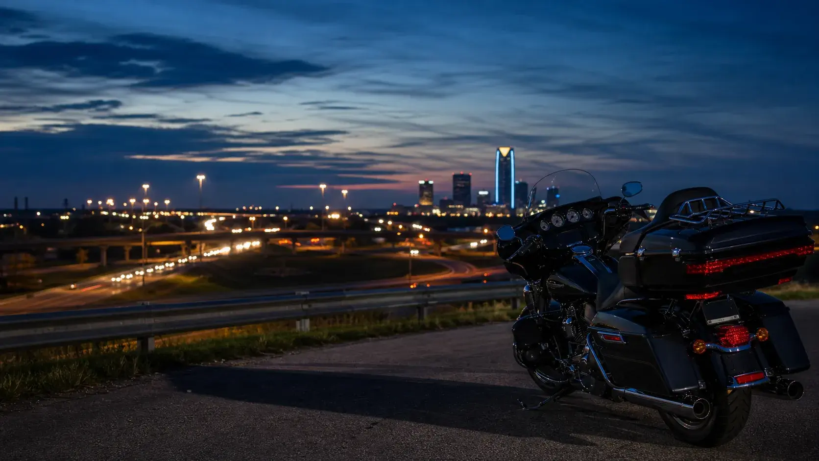 Motorcycle parked safely above Oklahoma City highway corridors at dusk