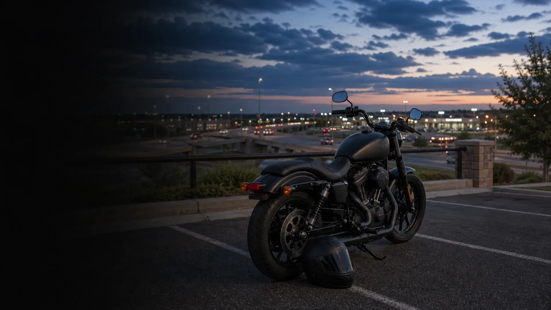 Motorcycle parked safely near an Owasso growth corridor with US-169 style roadway context at blue hour