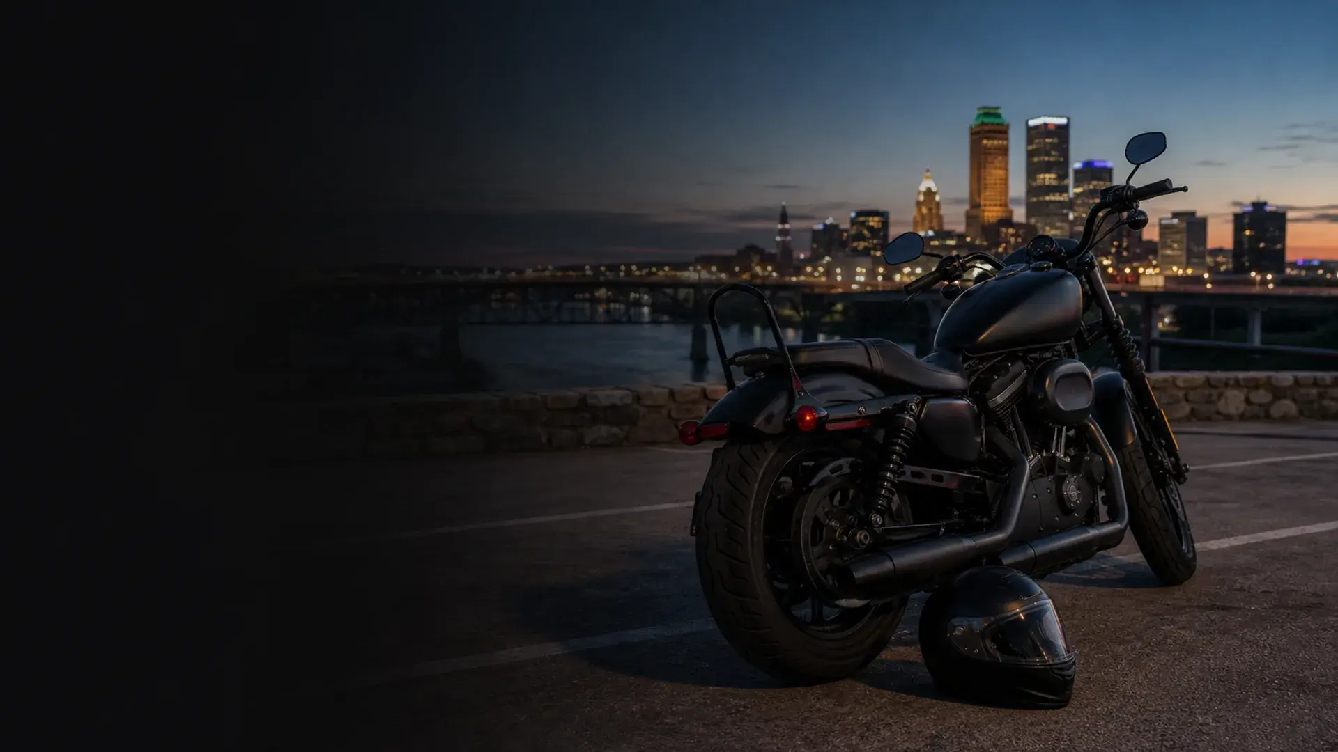 Motorcycle parked safely near Tulsa river and skyline with expressway traffic in the distance at blue hour