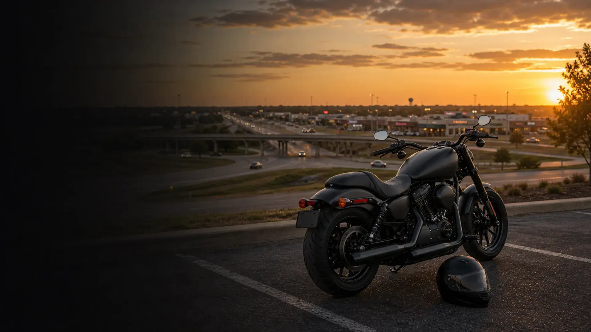 Motorcycle parked safely near a Yukon commuter corridor with I-40 and suburban roadway context at sunset